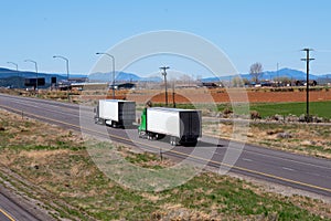 Big rig semi trucks convoy with semi trailers going on straight