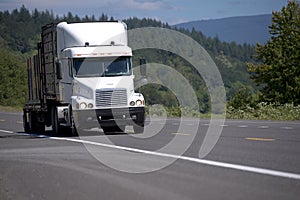 Big rig white Semi truck with combine trailers running on green