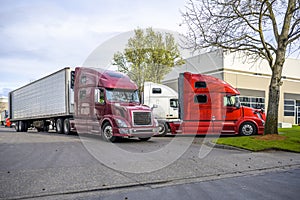 Big Rigs Semi Trucks congestion with semi trailers on the warehouse parking lot waiting for loading or unloading cargo in dock