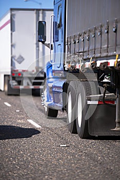 Big rigs semi trucks convoy with different trailers for long and photo