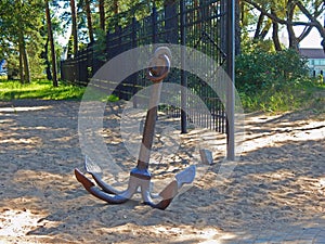 A big river anchor lying in the sand