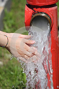 big road hydrant and the refreshing water that comes out copious and the hands of a child
