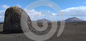 Big rock alone in the desert with volcans