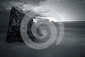 Big rock in the middle of the sea hit by waves