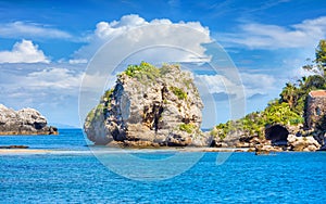 Big rock and narrow path connecting Isola Bella island to mainland Taormina beach, Sicily, Italy