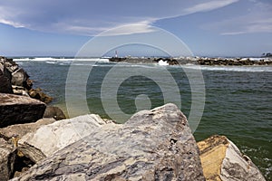 Big rocks and ominous storm in Australiaclouds in sky over water at breakwall on Wooli Wooli River photo