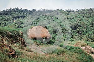 Big rocks and view to the valley everywhere is green plants and trees and stones in between river stream flowing