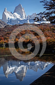 Big rocky peak mountains with snow with the reflection on water. Autumn season in El Chalten, Patagonia, Argentina photo