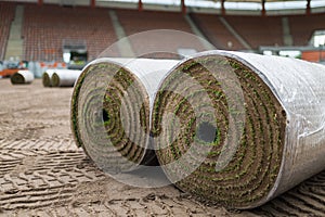 Big rolls of grass lays on a football field