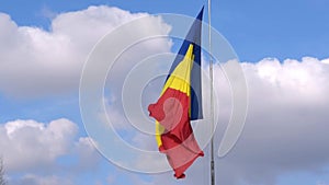 Big Romania Flag on post moving in the wind. Romanian red, yellow and blue flag waving in the wind.