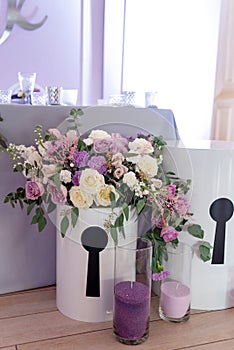 Big round box with flowers and glass flasks with candles. Modern wedding decor