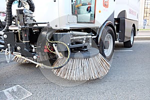 Big round broom of street sweeper with wide sweeping path and maintains contact with pavement on its own