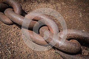 Big rusty chain on floor closeup - anchor chain