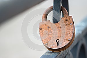 Big rusty padlock on fence