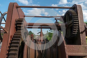 A big rusty pinion mechanism on the deck of an old ferry. Old rusty vintage mooring bollard for boats, ships and yachts. Control