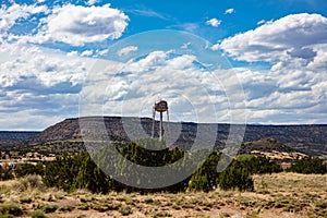 Big, rusty water tank on a tower near the city, reminds us of the old western usa. Chinle, Arizona, US