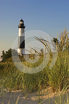 Big Sable Point Lighthouse surrounded by greenery and sand under the sunlight in Michigan