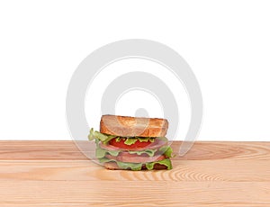 big sandwich with fresh vegetables on wooden board on white