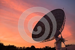 Big Satellite Dish or radio telescope at dusk with twilight sky