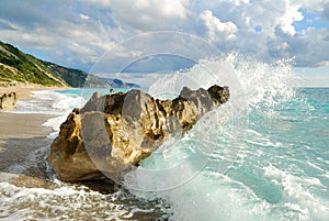 Big sea wave breaking on the beach rocks