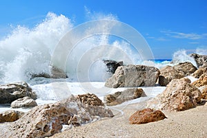 Big sea wave splashing over the shore rocks