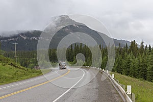 Big semi truck coming around the bend among the mountains