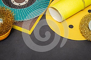 Big set of abrasive tools and yellow sandpaper on black background