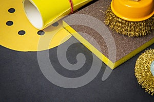 Big set of abrasive tools and yellow sandpaper on black background