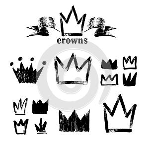 Big set of silhouettes of crowns. Black grunge icons. Painted by hand with a rough brush. Vector illustration. Isolated on white b