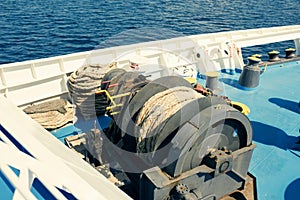 A big sheave with coiled hawser on the open deck of the ferryboat. Summer cruise in Greece