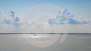 Big ship on the river and blue sky with clouds above it