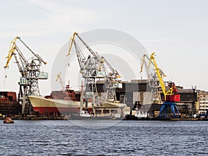 Big ship under repairing on floating dry dock in shipyard