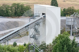 Big silos, belt conveyors and mining equipment in a quarry. photo