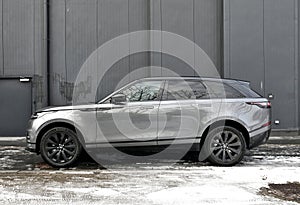 Big silver grey British 4WD compact luxury crossover car Range Rover Velar parked in ice and snow