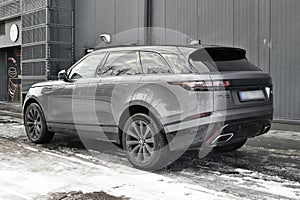 Big silver grey British 4WD compact luxury crossover car Range Rover Velar parked in ice and snow