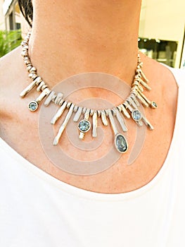 Big silver necklace on middle age woman`s neck