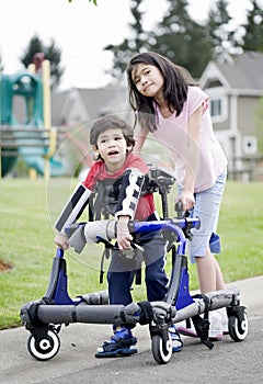 Big sister helping disabled brother walk