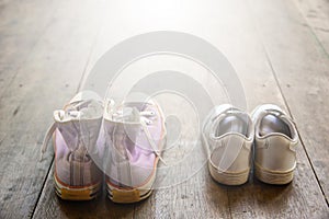 Big and small shoes on wooden Floor.