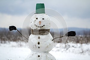 Big smiling snowman with bucket hat, scarf and gloves on white s