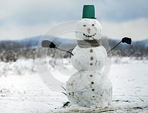 Big smiling snowman with bucket hat, scarf and gloves on white s
