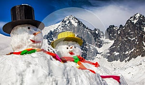 Big snowmans in winter snowy country. Peak Lomnicky stit in High Tatras mountains in Slovakia at background