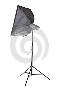 A big softbox isolated on a white background. A professional studio equipment. A black studio flash on a long tripod. Outbreak.