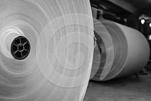 Big Stack of Printing Paper Rolls in Warehouse. The concept of production of paper and paperboard. Industry, copy space. Black and
