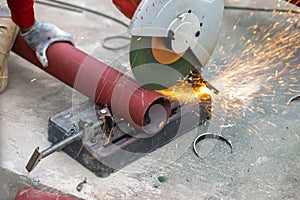 Big steel pipe pipes are being cut from steel cutters by construction workers. Large iron hollow Use it as a roof pole. Sparking