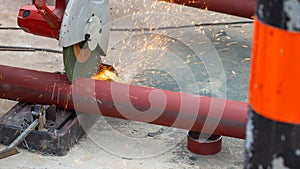 Big steel pipe pipes are being cut from steel cutters by construction workers. Large iron hollow Use it as a roof pole. Sparking