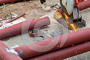 Big steel pipe pipes are being cut from steel cutters by construction workers. Large iron hollow Use it as a roof pole. Sparking