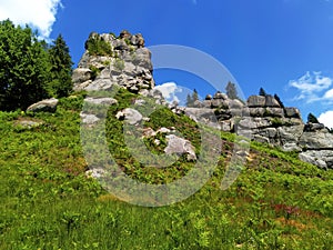 Big stone cliffs in the mountains.Bright summer mountain landscape. Ruins at the site of an ancient castle.