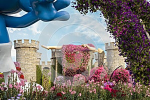Big stone fairytale castle with a sleeping beauty in botanical Dubai Miracle Garden with different floral fairy-tale themes in