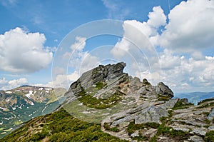 Big stone scaur in Carpathian mountains with the blue sky and white clouds photo