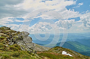 A big stone scaur and green hills in Carpathian mountains in the summer. Mountains landscape background photo